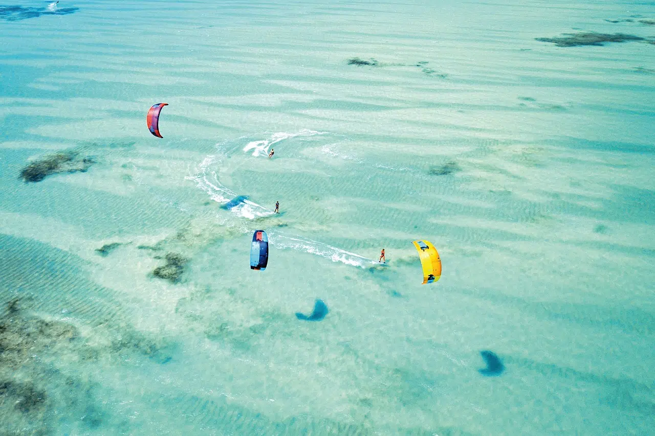 Kitesurfer gleitet über türkisblaues Wasser vor der Küste Sansibars